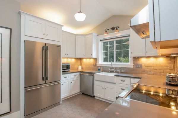 a kitchen with white cabinets and stainless steel appliances